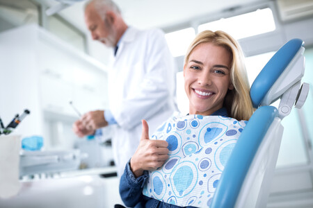 Smiling and happy young woman after successful treatment without pain